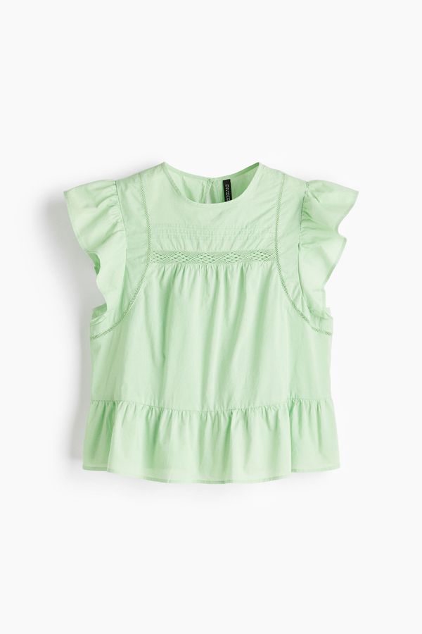 Blusa con inserciones de encaje y peplum