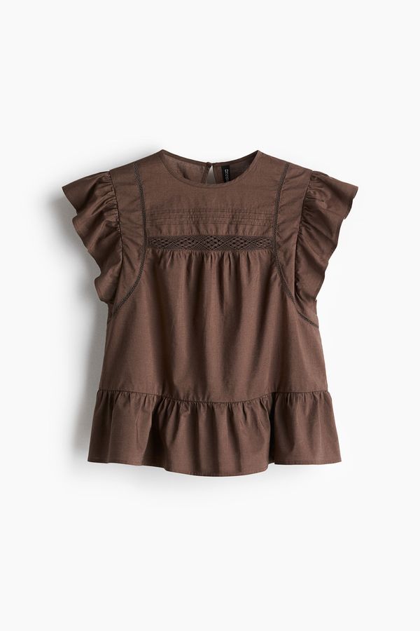 Blusa con inserciones de encaje y peplum