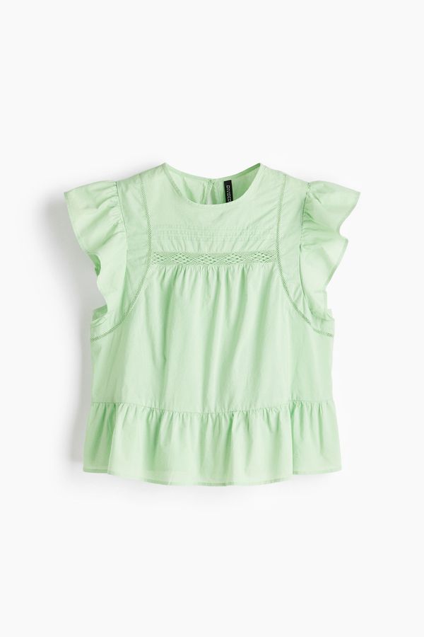 Blusa con inserciones de encaje y peplum
