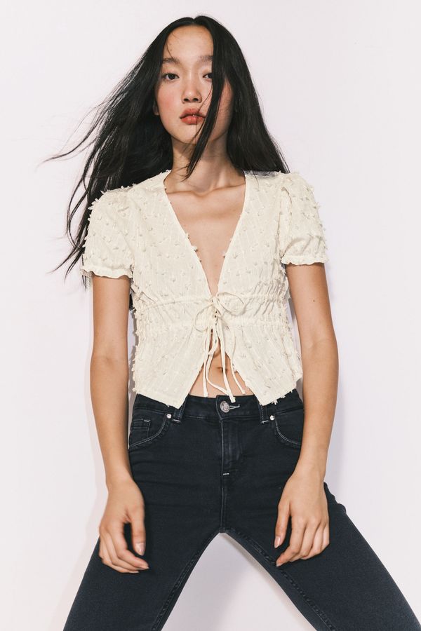 Blusa en plumeti con cierre de tiras de anudar